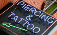 immagine con l'insegna di un negozio di tattoo e piercing